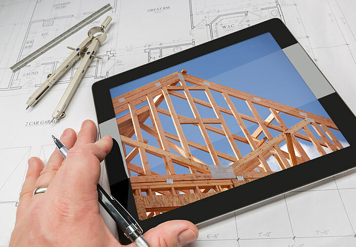 Tablet mit Abbildung einer Dachkonstruktion auf Zeichentisch