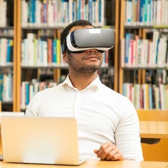 Mehrere Menschen sitzen mit VR-Brillen in einer Bibliothek 