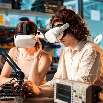 Junge Männer und Frauen mit VR-Brillen machen Experimente zur Robotik in einem Labor.