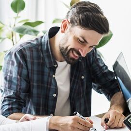 gruppe lachender Geschäftsmänner am tisch sitzend und am arbeiten 