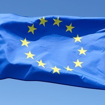 Flagge der Europäischen Union auf einem Flaggenmast im wind wehend for einem hell blauen Himmel 