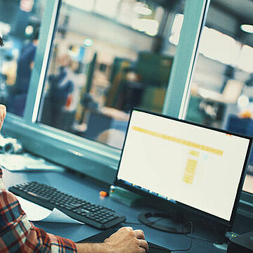Ein Mann schaut auf einen Produktions-Monitor.