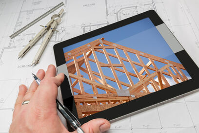 Tablet mit Abbildung einer Dachkonstruktion auf Zeichentisch