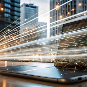 Bild von einem Computer mit abstrakten Lichtpfeilen vor dem Hintergrund einer Großstadt