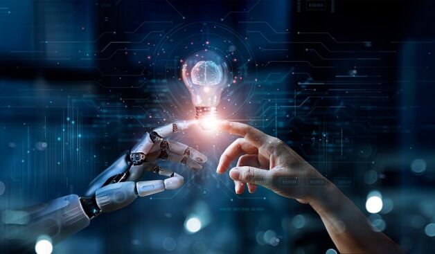 Roboterhand trifft Menschenhand, in der Mitte eine Glühbirne