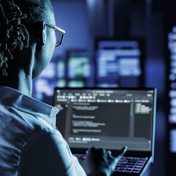 Frau mit Laptop in Hand vor vielen Servern 