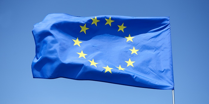 Flagge der Europäischen Union auf einem Flaggenmast im wind wehend for einem hell blauen Himmel 