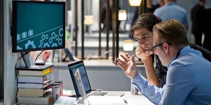 Bild von zwei Personen, die sich am Computer verschiedene Grafiken ansehen und darüber diskutieren.