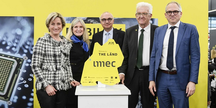 Eine gruppe von fünf personen vor einem Baden-Württemberg förmigen Schild mit der Aufschrift "The Länd" und "imec"