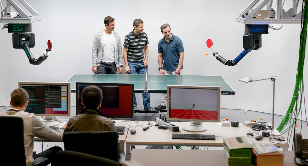Labor: Roboter spiele Tischtenisch und Personen schauen zu