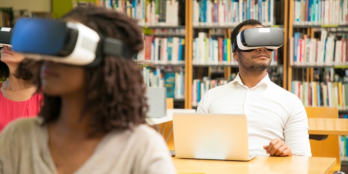 Mehrere Menschen sitzen mit VR-Brillen in einer Bibliothek 